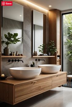 two white sinks sitting on top of a wooden counter next to a large glass window