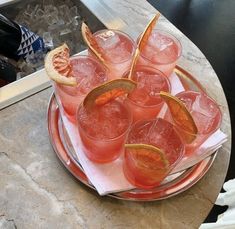 there are many glasses on the plate with orange slices