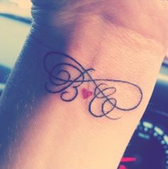 a small tattoo on the wrist of a woman's left arm with an infinite symbol