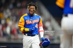 a baseball player with dreadlocks on his head walking off the field during a game