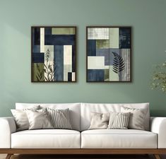 two paintings hang on the wall above a white couch in a living room with green walls