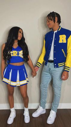 a man and woman dressed up in cheerleader outfits, standing next to each other