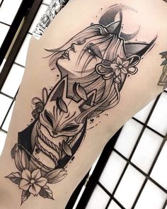 a woman's thigh with an owl and flower tattoo design on her leg,