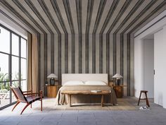 a bedroom with striped walls and flooring next to a bed in front of large windows