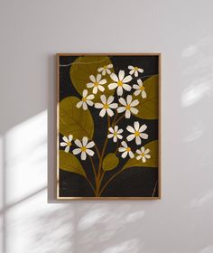 a painting hanging on the wall with white and yellow flowers in it's center