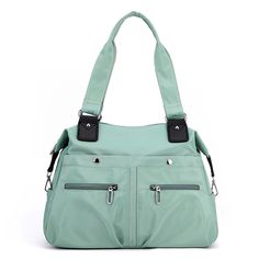 a mint green purse with two zippers on the front and one side pocket open