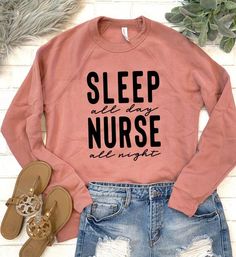 a pink sweatshirt with the words sleep all day, nurse are night on it next to ripped shorts