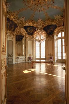 an ornate room with chandeliers and paintings on the walls is pictured in this image