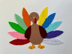 a paper turkey with colorful leaves on it