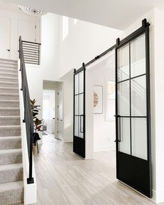 an open door leading to the second floor in a house with white walls and wood floors