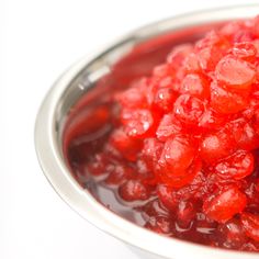 a bowl filled with red jelly sitting on top of a table