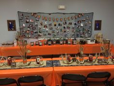 an orange table topped with lots of plates and cups