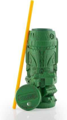 a green tiki mug with a yellow straw in it and a plastic cup next to it