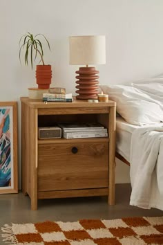 a bedroom with a bed, nightstand and pictures on the wall