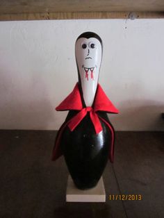 a black and white vase with a red ribbon around it's neck is sitting on a table