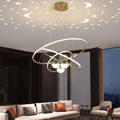 a living room filled with furniture and a chandelier hanging from the ceiling above it