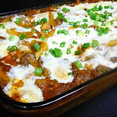 a casserole dish with meat, cheese and green onions