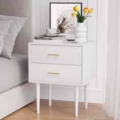 a white nightstand with yellow flowers on it