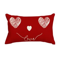 a red pillow with two hearts on it and the word love written in white ink