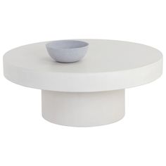 a white round table with a bowl on it's top and one side facing the camera