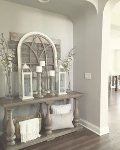 a table with some candles on top of it and flowers in vases next to it