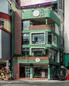 a tall green building sitting on the side of a road