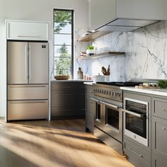 a modern kitchen with stainless steel appliances and wood flooring