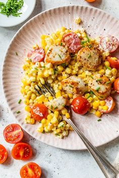 a white plate topped with corn, tomatoes and scallops