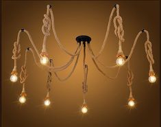 a chandelier with rope and lights hanging from it's sides on a brown background