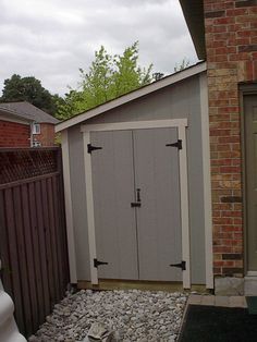 an outdoor storage shed with gravel and rocks