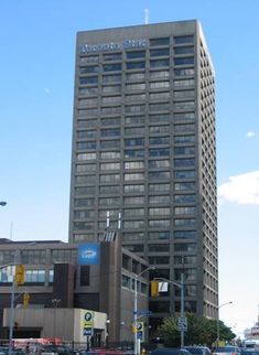 an office building in the city with cars parked on the side of the street near it