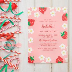 a pink birthday party card with strawberries and flowers on it next to candy canes