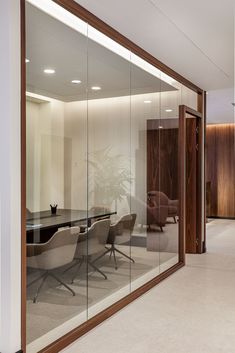 an empty conference room with glass walls and chairs