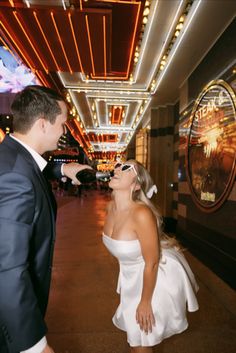 a woman in a white dress standing next to a man