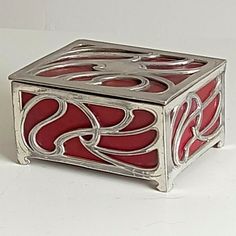 a red and silver box sitting on top of a white table