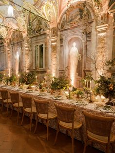 a long table is set with candles, flowers and greenery for an elegant dinner