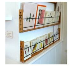 two wooden shelves filled with cards on top of a white wall next to each other