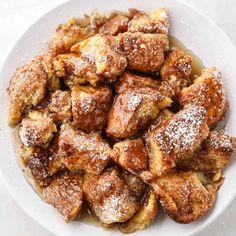 a white plate topped with powdered sugar covered pastries