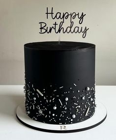 a black and white birthday cake with sprinkles