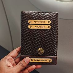 a person holding up a brown wallet on an airplane