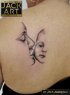 the back of a woman's shoulder with a drawing of two faces on it