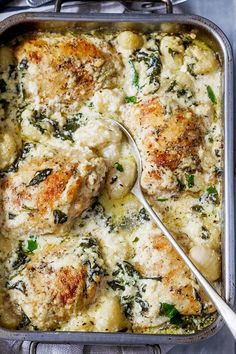 chicken and spinach casserole in a pan with a spoon on the side