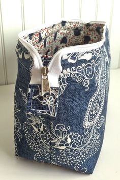 a blue and white bag with a zipper on the inside is sitting on a table