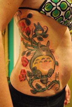 a woman with a tattoo on her stomach has an image of totoro and flowers