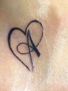 a small heart tattoo on the side of a woman's neck with scissors in it