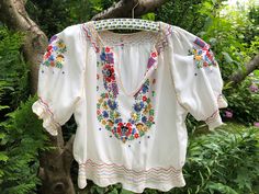 Vintage 40s Hungarian peasant blouse. Silk crepe hand embroidered colorful short sleeve cropped blouse. Traditional Hungarian Matyó floral pattern. The waist and the cuffs are smocked. In excellent vintage condition  To fit XS/S size  Sleeve length from neckline to cuff 12,5" 32cm Bust 41" 104cm Length 17" 43cm Multicolor Folk Style Short Sleeve Peasant Top, Multicolor Folk Peasant Top With Short Sleeves, Multicolor Short Sleeve Folk Peasant Top, Multicolor Peasant Blouse For Summer, Spring Short Sleeve Blouse With Multicolor Embroidery, Multicolor Embroidered Short Sleeve Blouse For Spring, Folk Style Short Sleeve Top For Festivals, Multicolor Bohemian Peasant Top With Short Sleeves, Peasant Style Short Sleeve Tops For Spring