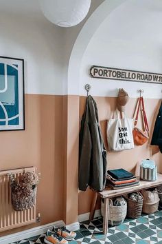 an entryway with coat racks, shoes and bags hanging on the wall next to it