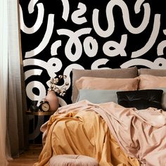 a bed sitting under a black and white wall next to a window