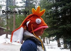 a young boy wearing a knitted hat with an orange and white bird on it