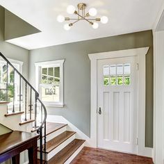 an empty entryway with stairs leading up to the front door and windows on either side